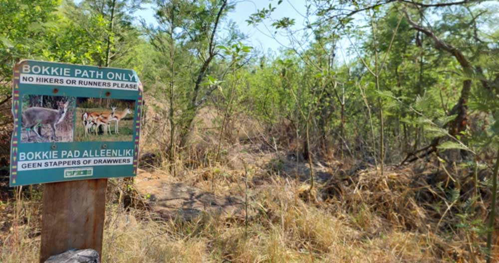 Sign reminding hikers not to go off track and stick to the main trails