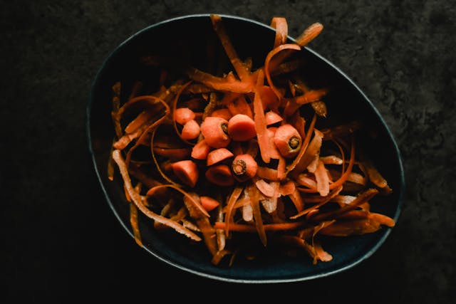 Carrot peels in a black bowl