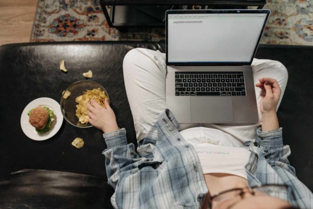 Eating and messing while working on a laptop. Photo: Pavel Danilyuk, Pexels